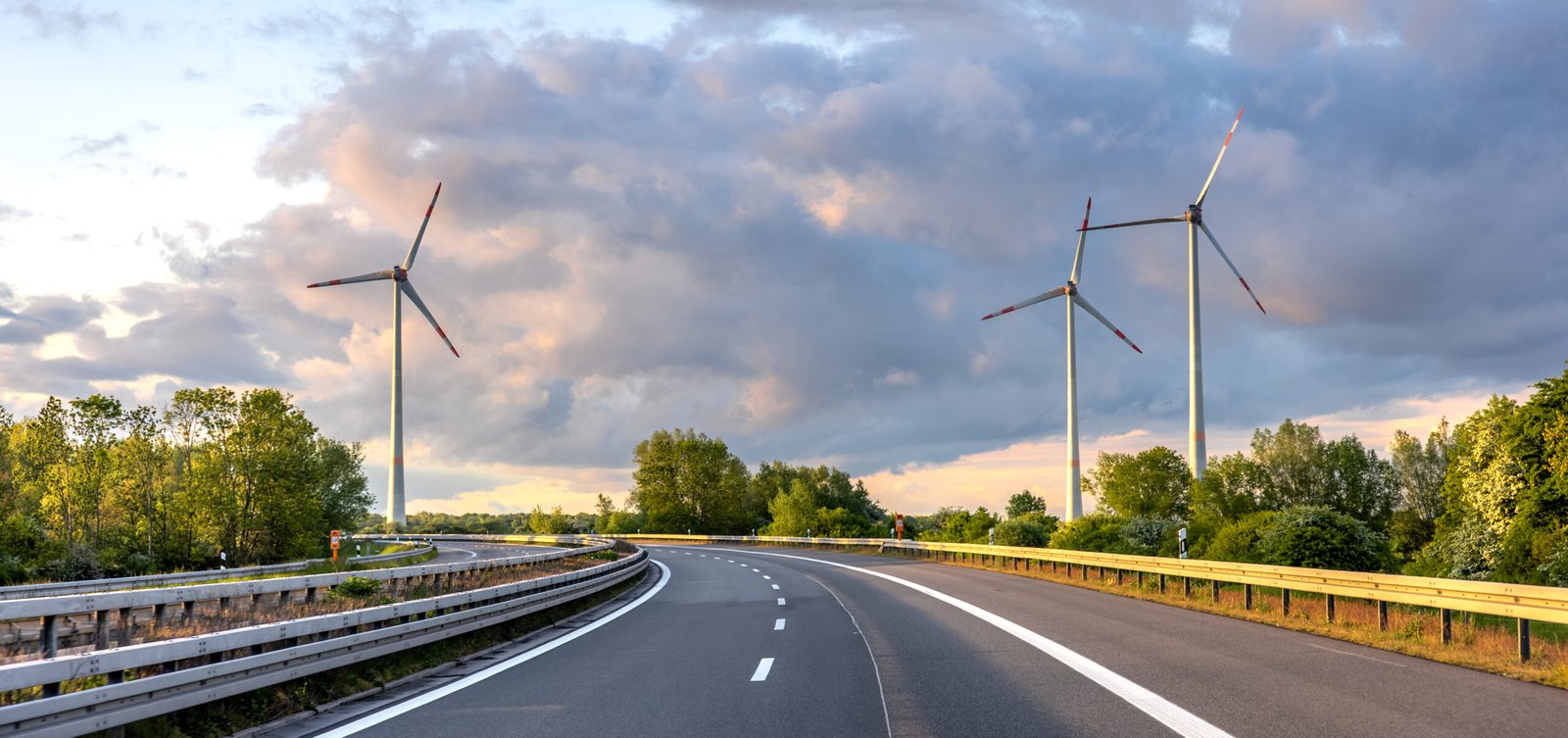 wind turbines by highway. eco travel. scenic infrastructure